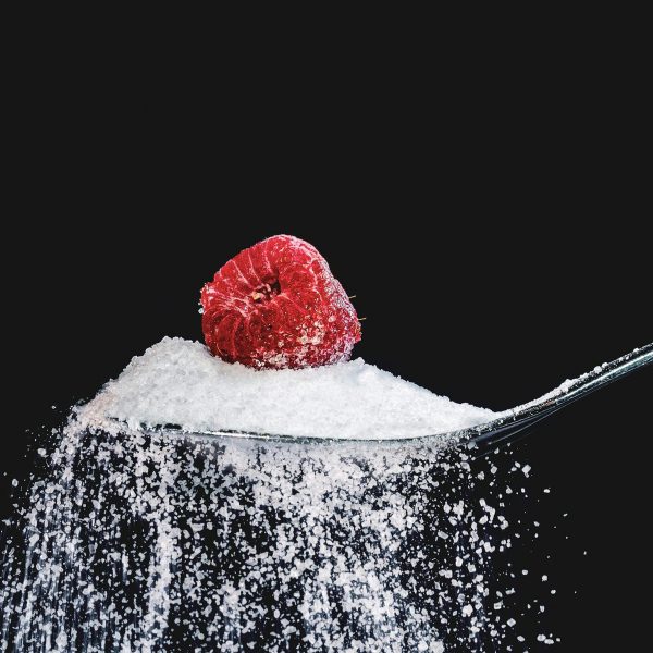 Spoon of sugar with berry on top