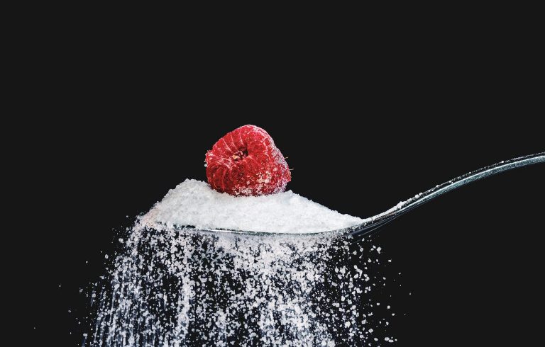 Spoon of sugar with berry on top