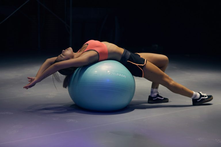 woman lying on exercise gym ball