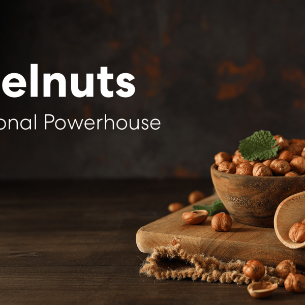 Bowl of hazelnuts on a wooden board with a scoop and a glass of hazelnut milk, representing the nutritional benefits of hazelnuts.