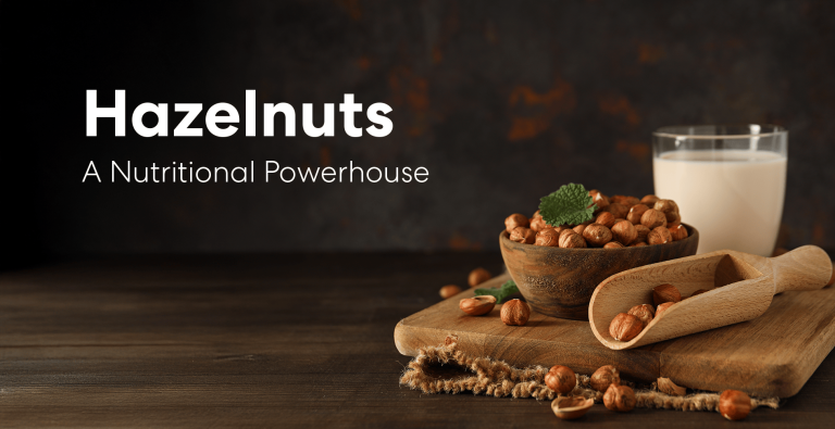 Bowl of hazelnuts on a wooden board with a scoop and a glass of hazelnut milk, representing the nutritional benefits of hazelnuts.
